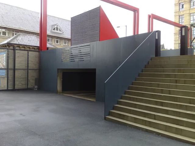 Red and grey architectural steel screens flanking an external public stair