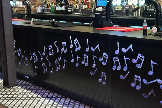 Bespoke music note metalwork detailing to a bar counter front