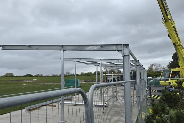 Steel canopy frame being craned into position on a green field site