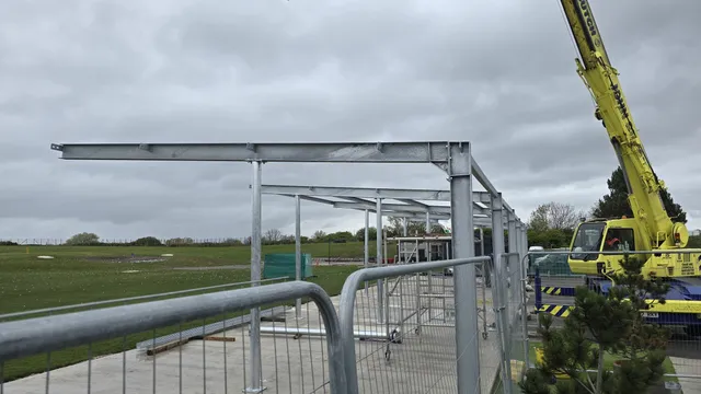 Steel canopy frame being craned into position on a green field site