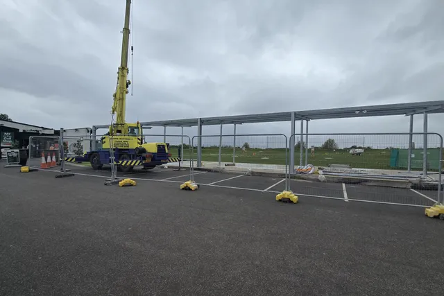 Steel canopy structure being installed by mobile crane on a commercial site