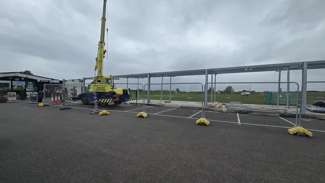 Steel canopy structure being installed by mobile crane on a commercial site