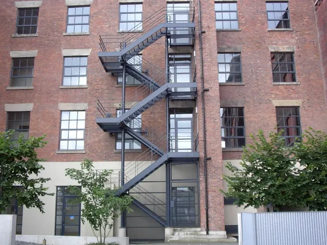 External steel fire escape staircase to a converted brick warehouse