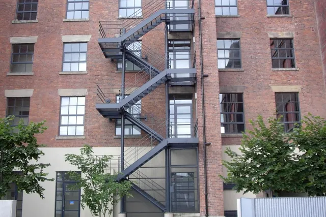 External steel fire escape staircase to a converted brick warehouse