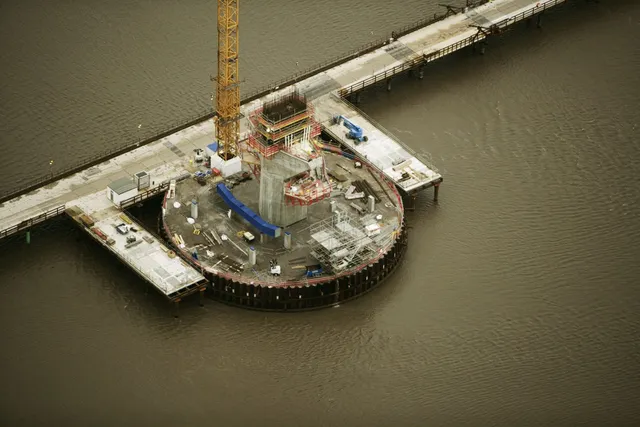 Aerial view of marine works with a circular steel structure in the water