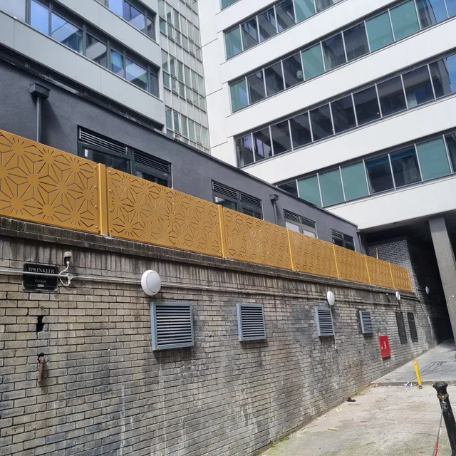 Perforated architectural screen panels to a mixed-use building elevation