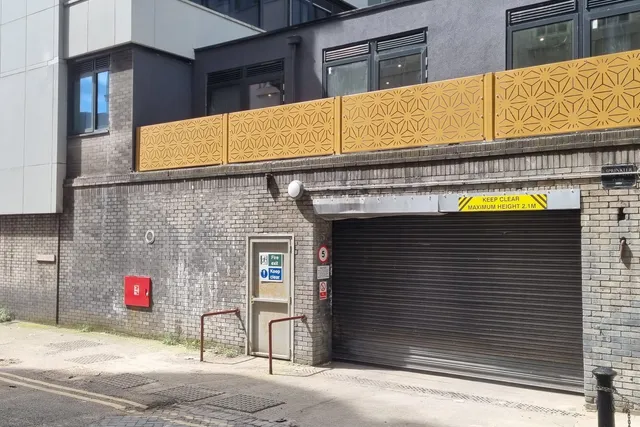 Gold perforated architectural screen panels fixed to a city centre facade