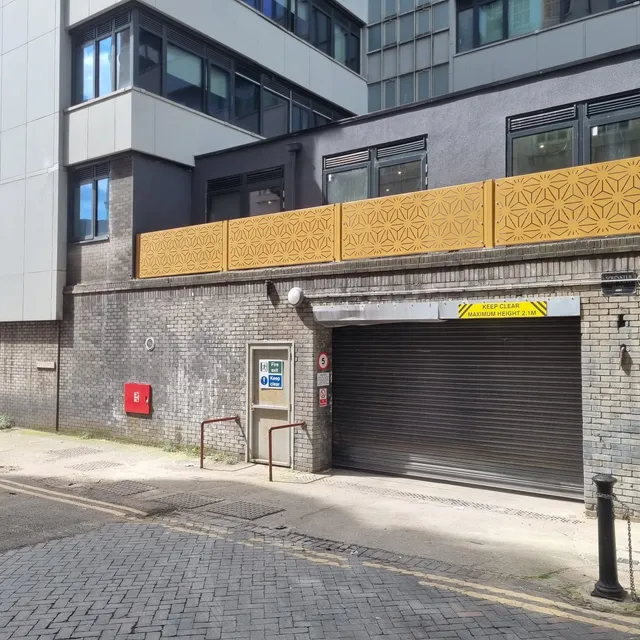 Gold perforated architectural screen panels fixed to a city centre facade