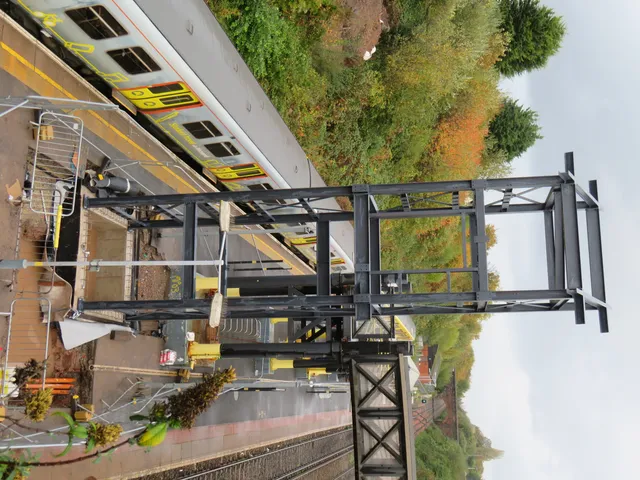 Steel railway footbridge span installed over the running line at a Merseyrail station
