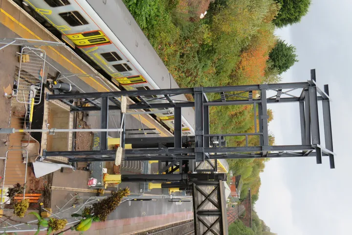 Steel railway footbridge span installed over the running line at a Merseyrail station