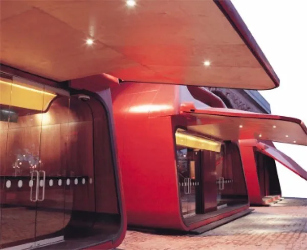 Curved red architectural steel canopy and cladding to a public building entrance