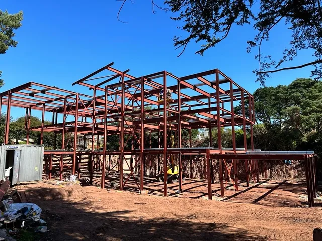 Red oxide primed structural steel frame under erection on a housing scheme