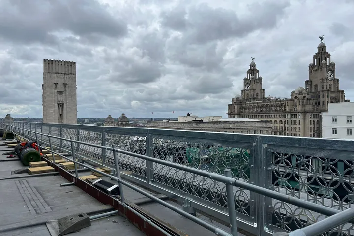 Rooftop balustrade run with the Royal Liver Building and Liverpool waterfront behind