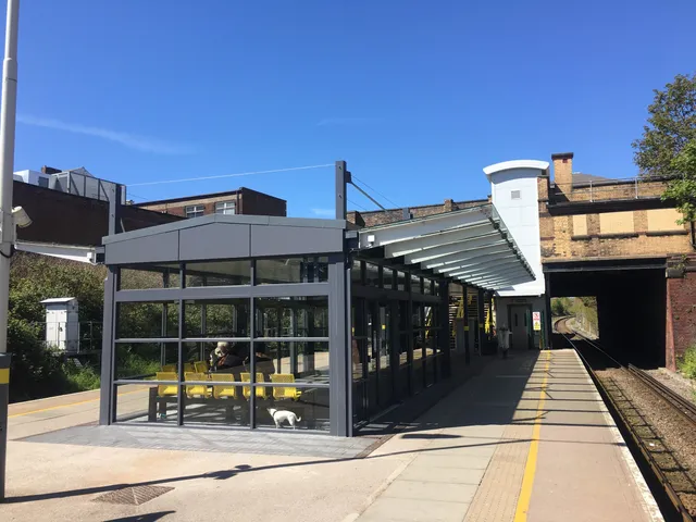 Glazed platform shelter and canopy steelwork at a Merseyrail station