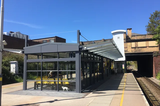 Glazed platform shelter and canopy steelwork at a Merseyrail station