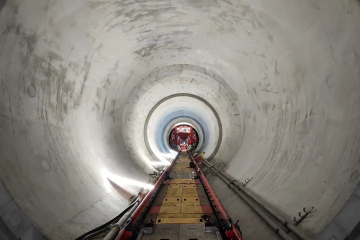 Steel gantry and track systems installed inside a concrete-lined tunnel drive